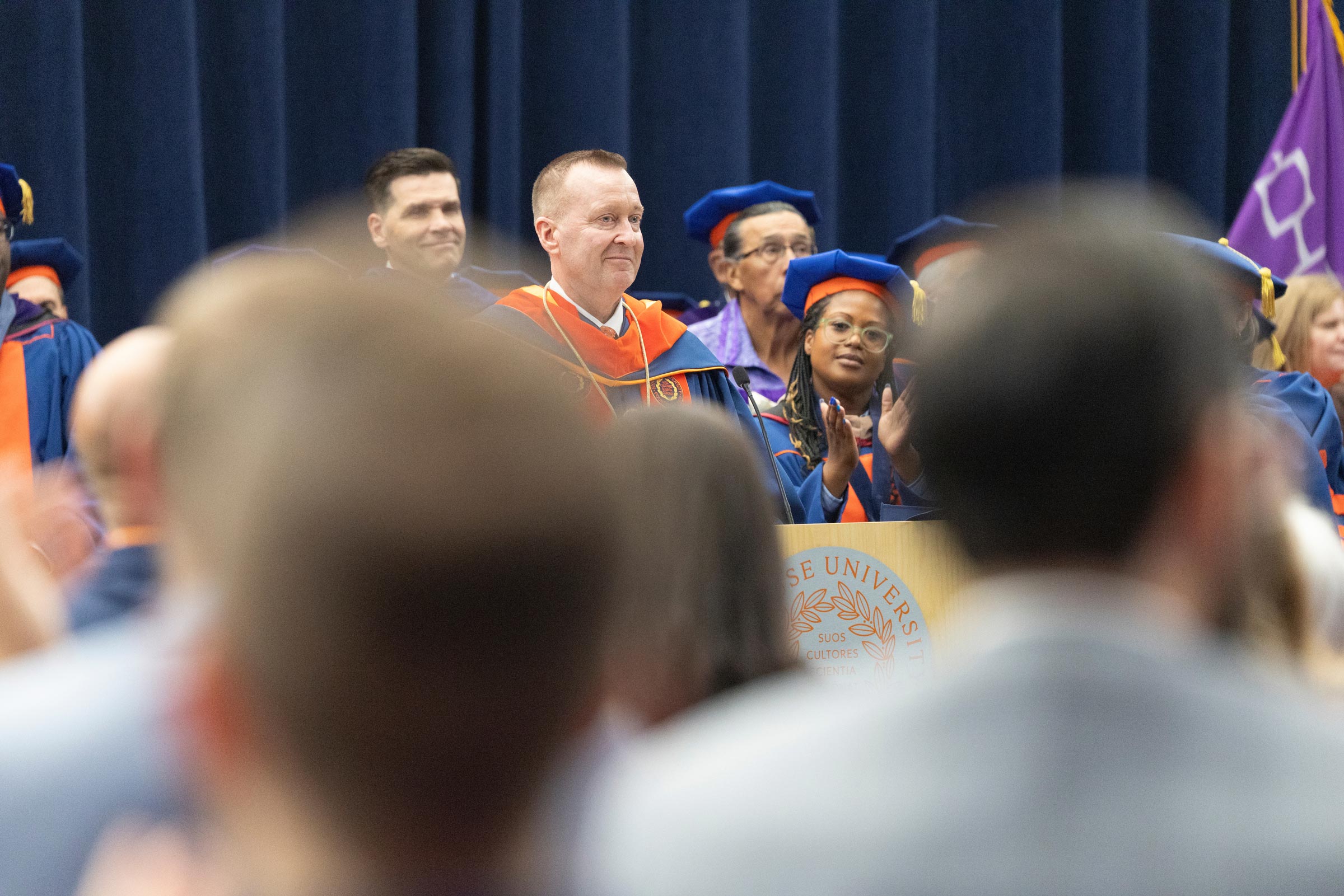 Chancellor Mike Haynie stands at the podium as the audience gives him a standing ovation after his speech 