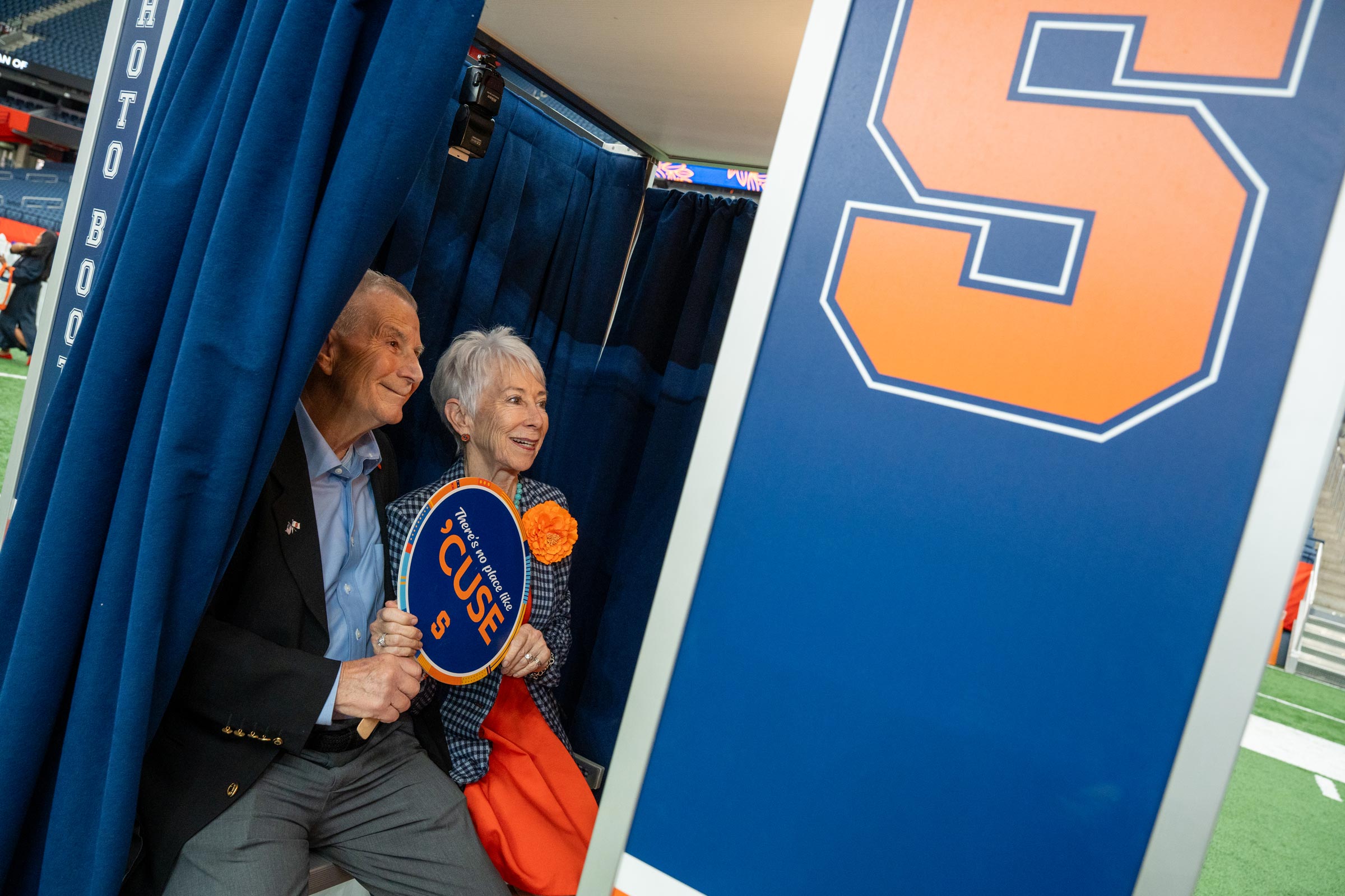 A couple pose for a picture in the Syracuse Photo booth during Orange Fest