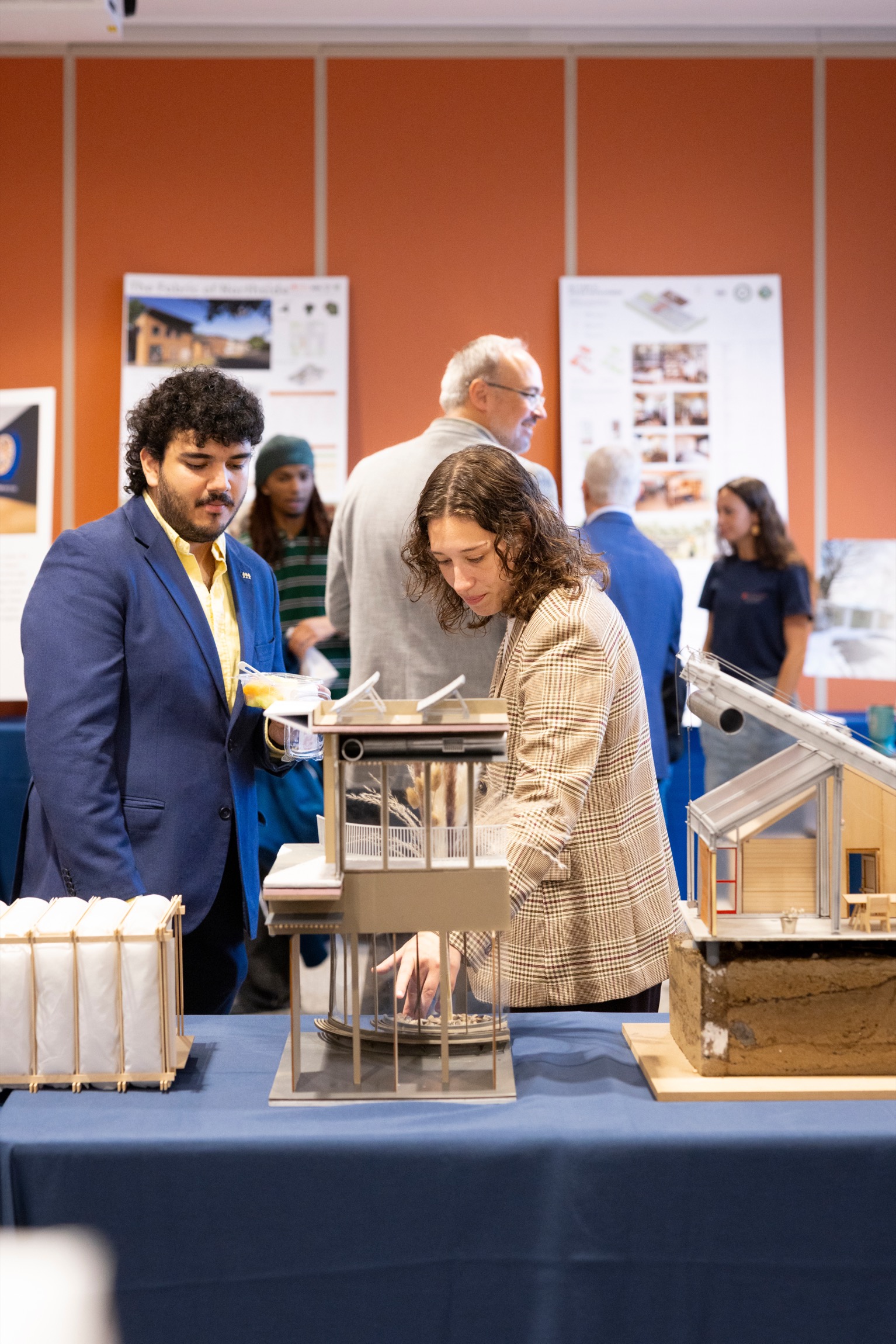 Two people look at an architectural model. 
