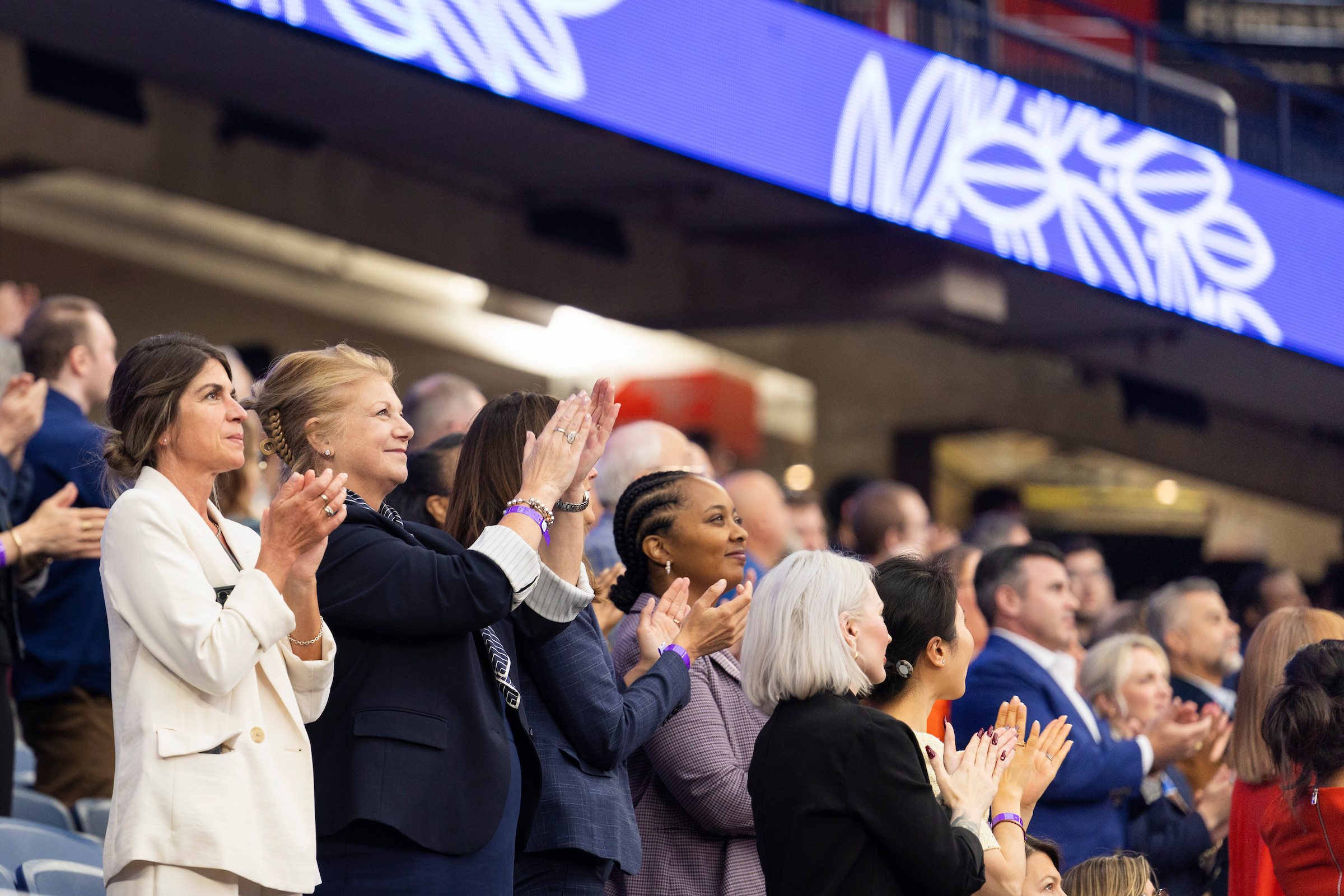 The crowd in the dome stands and claps during the ceremony.
