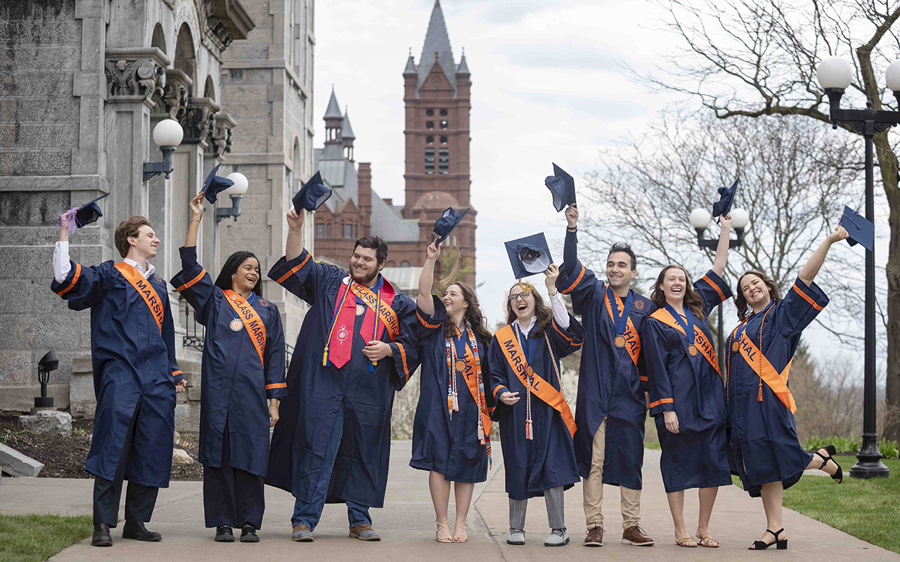 Graduating 'Syracuse Scholars' tossing their caps into the air