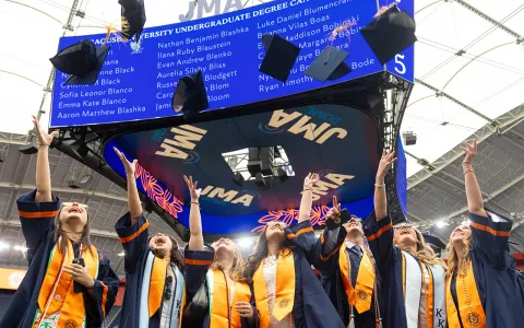 Students tossing their hats into the air in the Dome