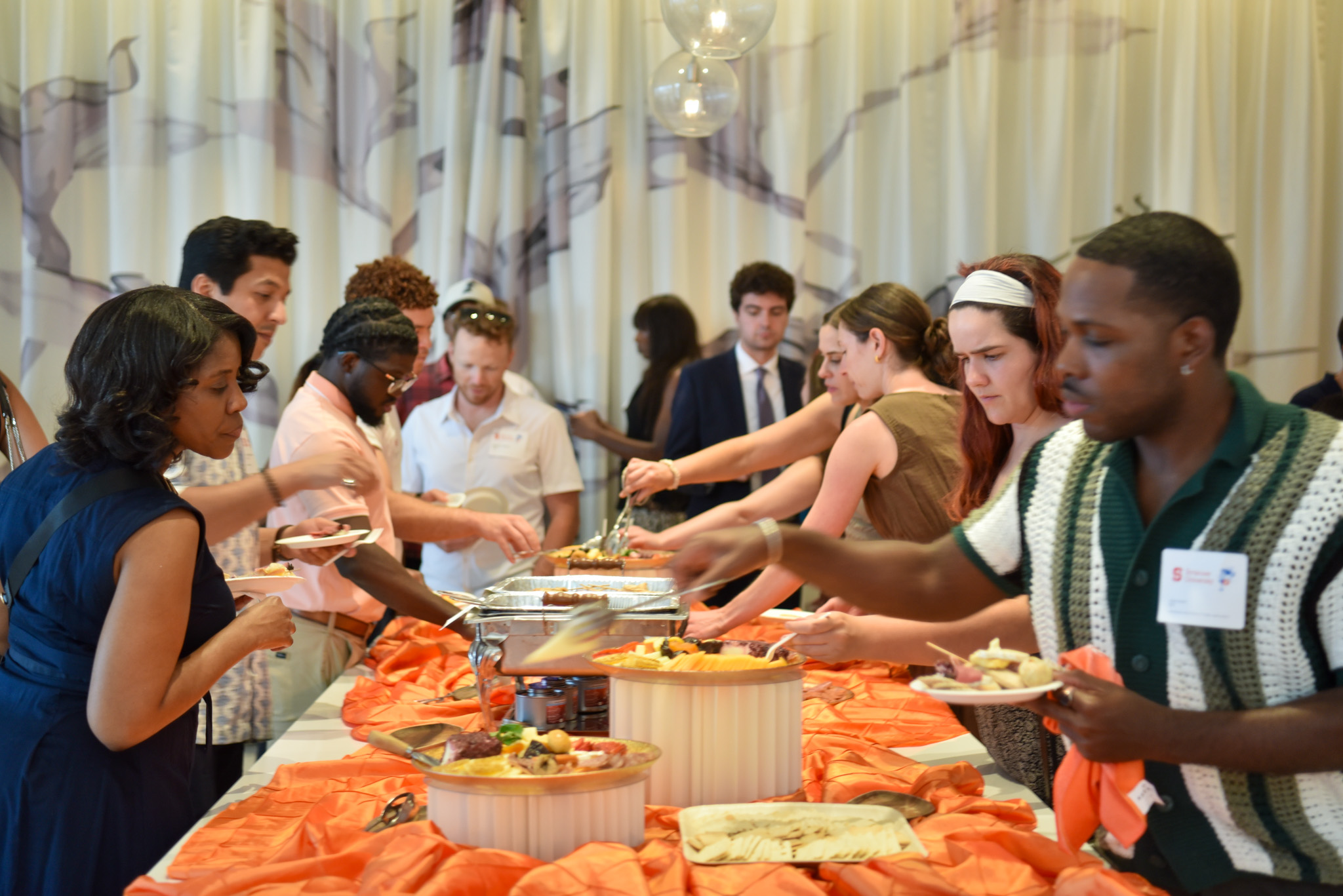 People taking food at buffet table at wine appreciation.