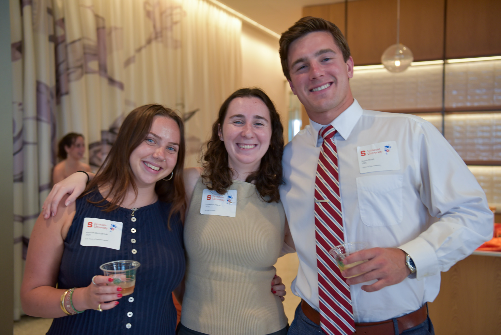 Three people posing for photo at wine appreciation.