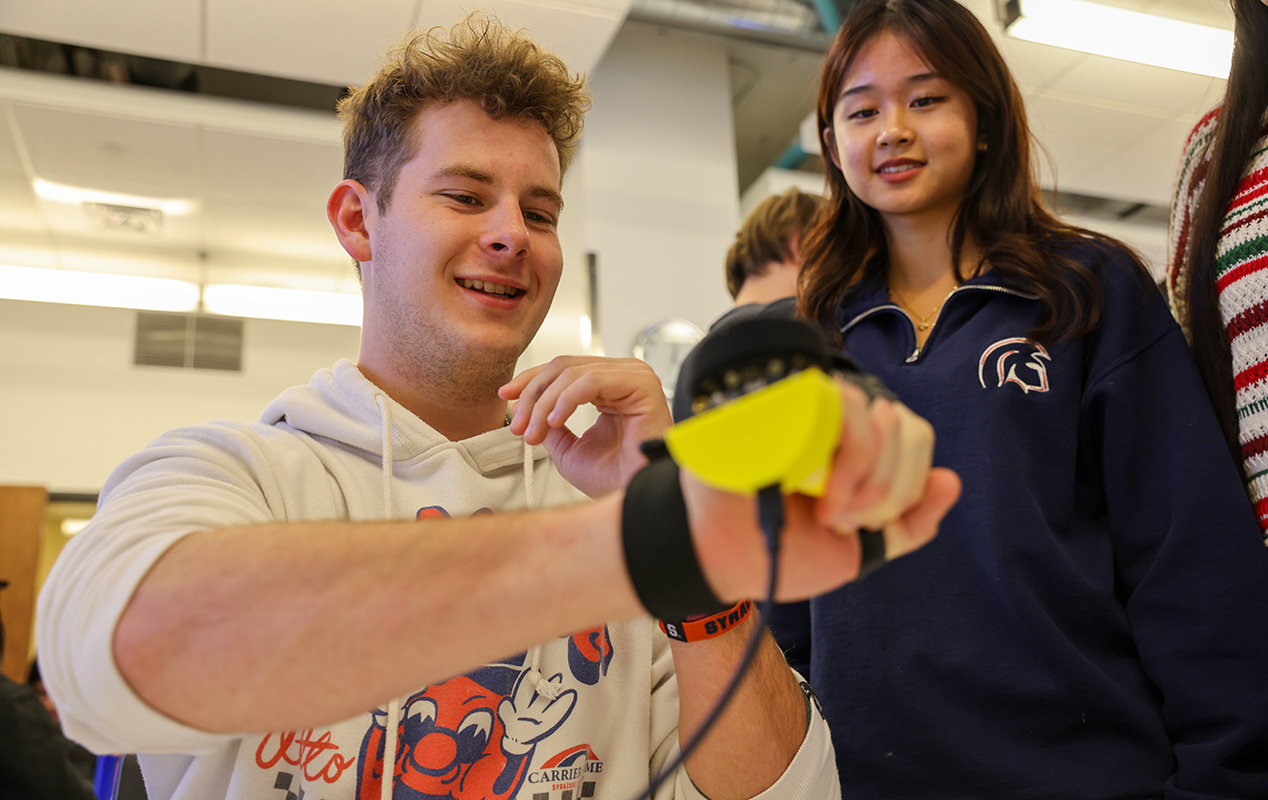 A boy and a girl look at an electronic glove