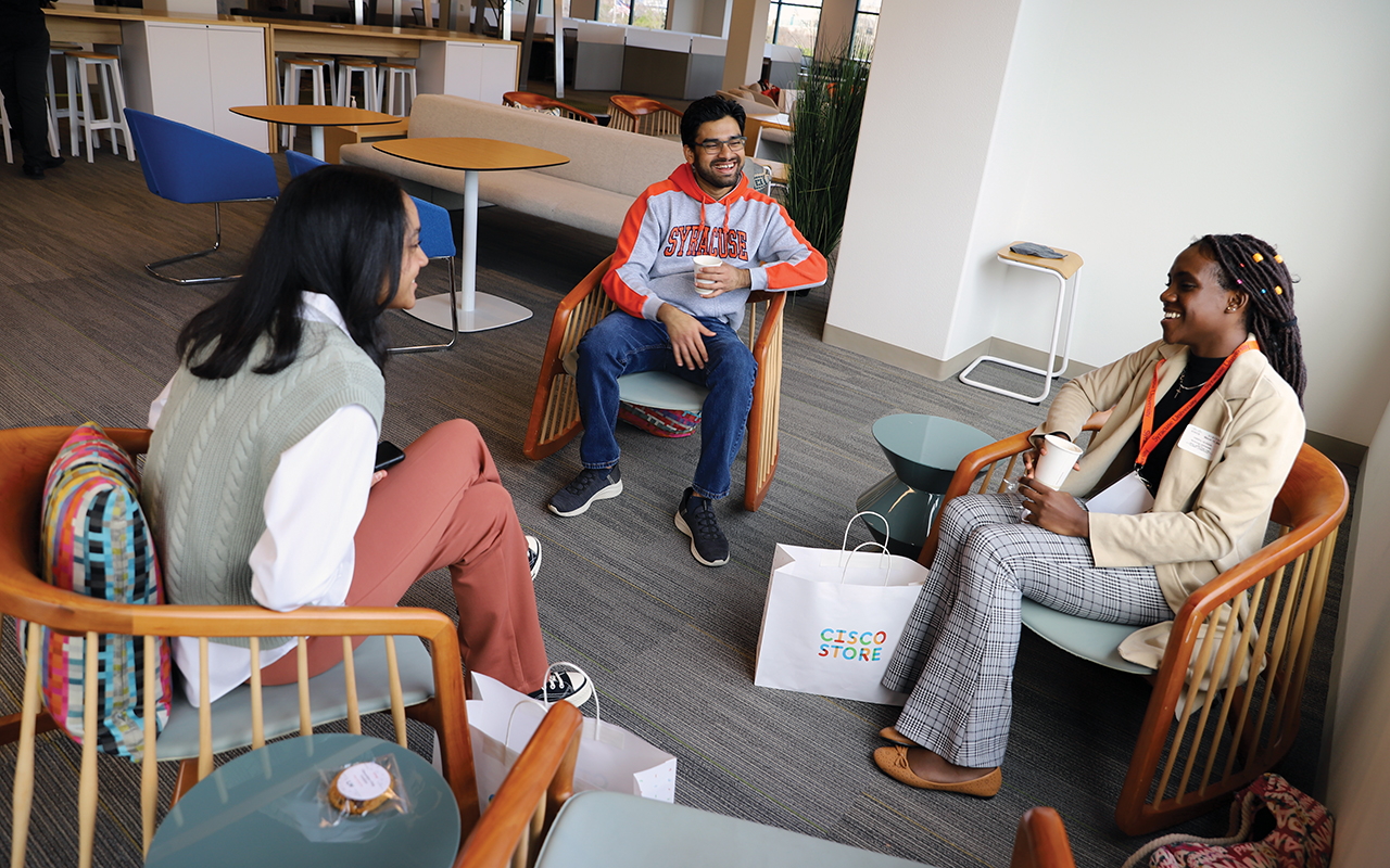 A man and two women sitting in chairs.