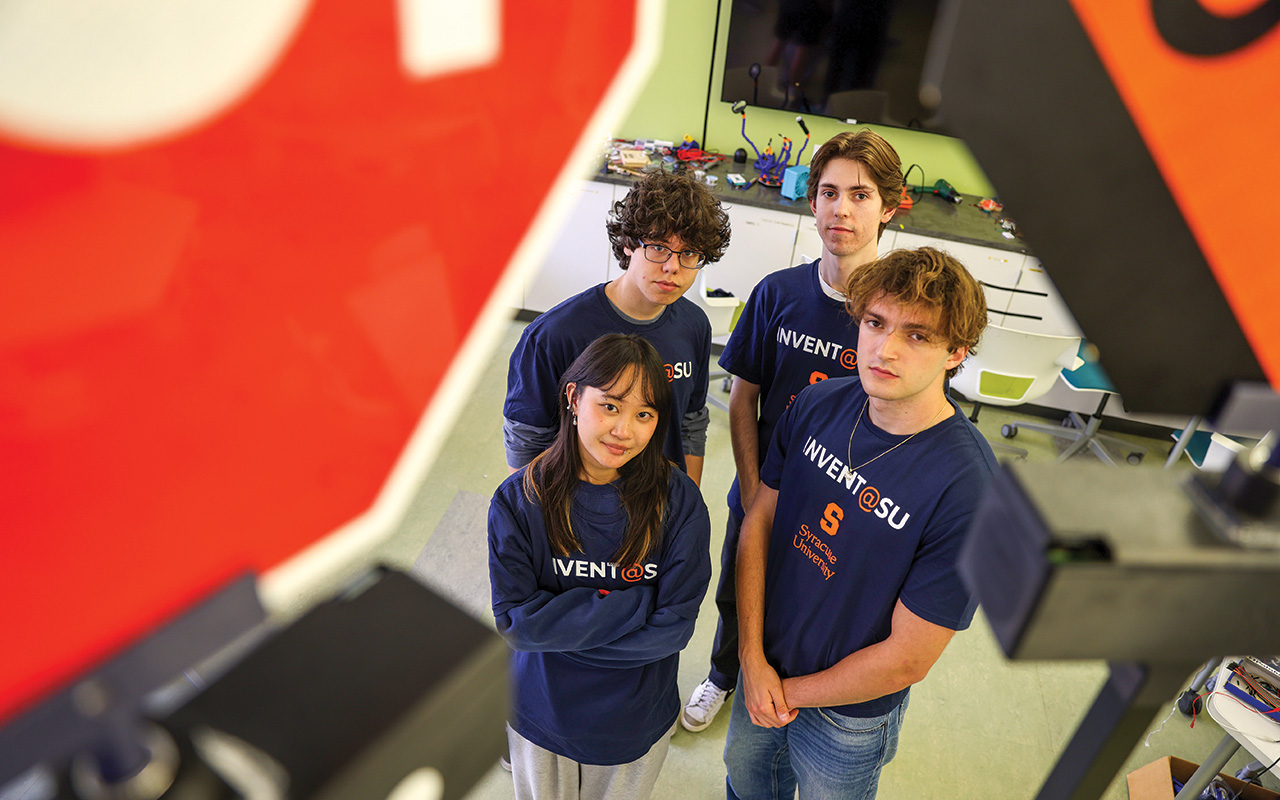 Three boys and a girl standing looking up