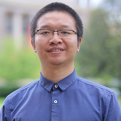 A man wearing glasses and light blue shirt.