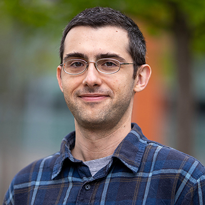 A man with glasses wearing a plaid shirt.