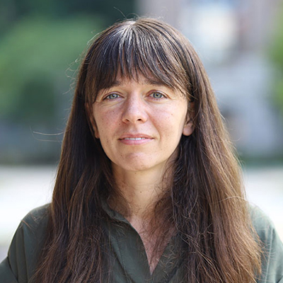 A woman with brown hair in a green shirt.