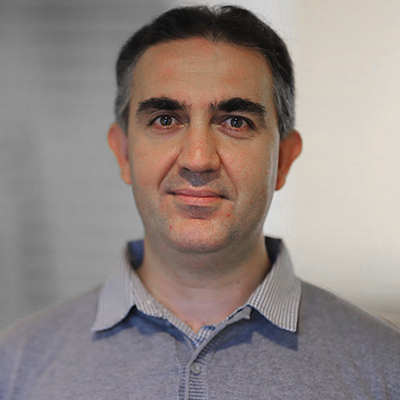 A man with greying hair in a grey shirt.