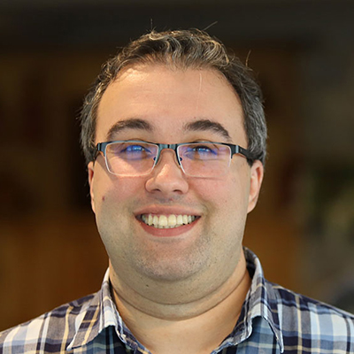 A man wearing glasses and a checkered shirt.