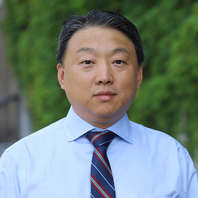 A man in blue dress shirt and stripped tie.