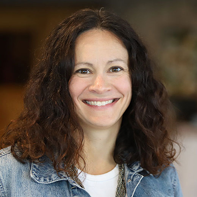 A woman with dark hair smiling.