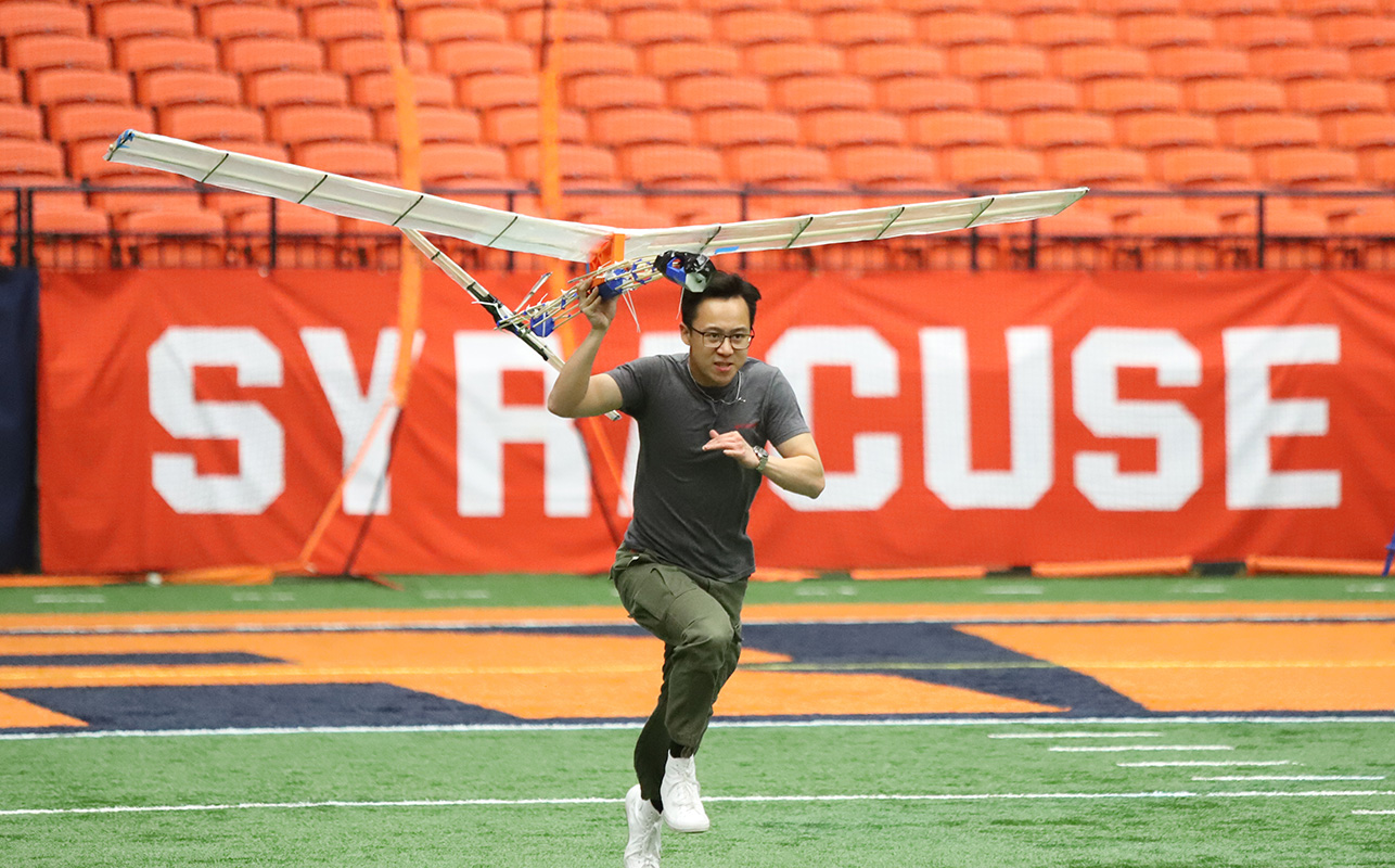 Student Running with an experimental aircraft during flight day in the JMA Wireless Dome