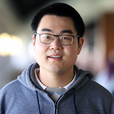 A man wearing glasses and smiling.