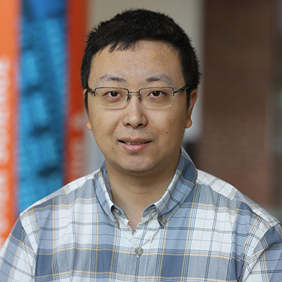 A man wearing glasses and smiling.