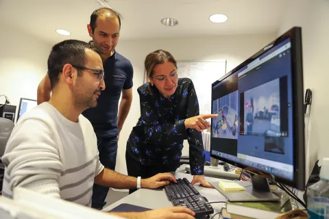 Senem Velipasalar and two students looing at a computer monitor