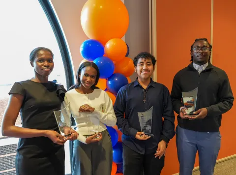 Two men and two women posing with awards