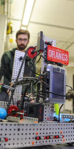 A robotic device with a man sitting behind it