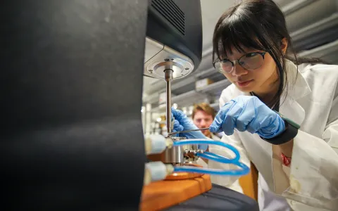 A girl using a piece of lab equipment.