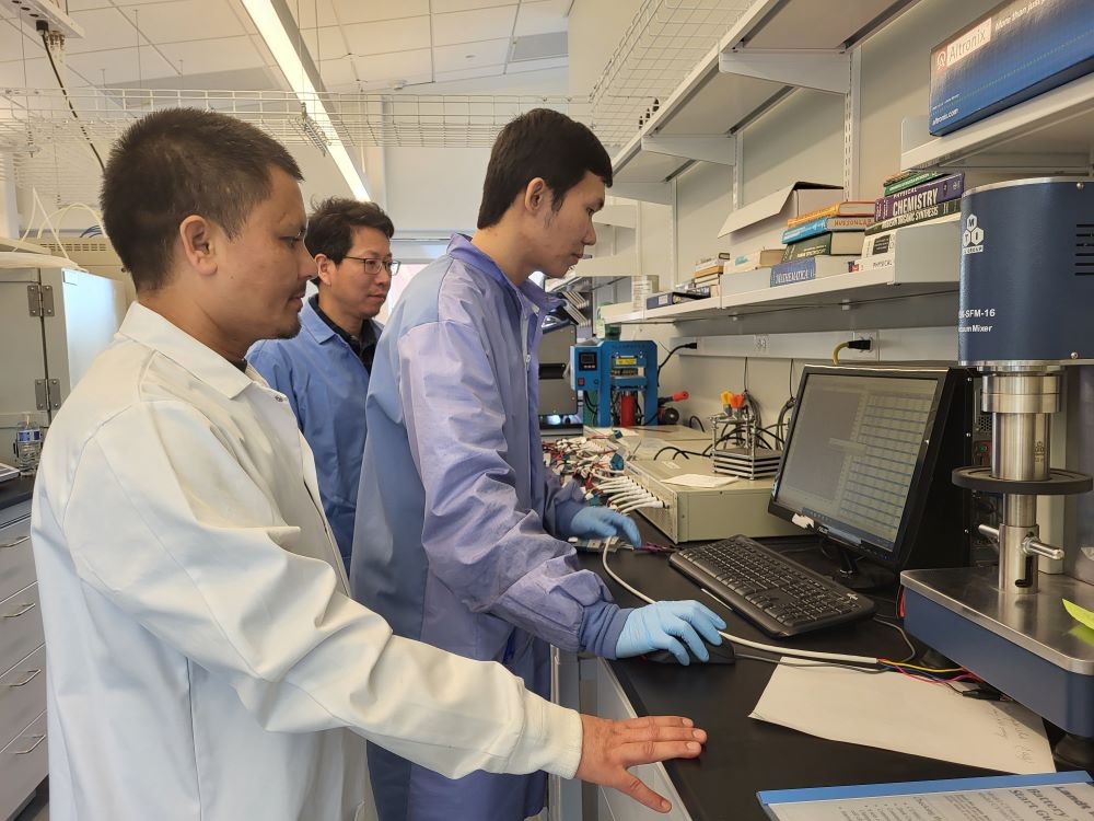Quinn Qiao and two graduate students working on battery research in his lab