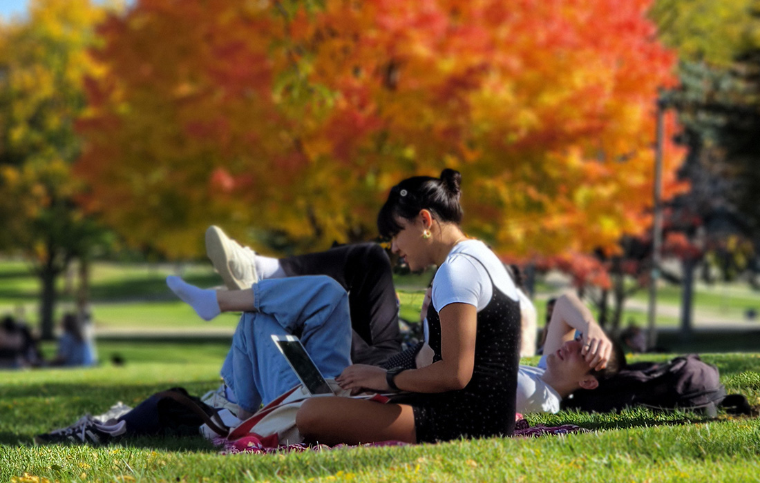 Students relaxing on campus during the fall