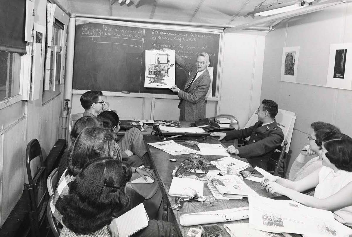Military students in a classroom with professor and chalkboard