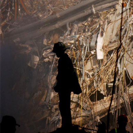 Firefighter silhouetted against the rubble of the World Trade Center.