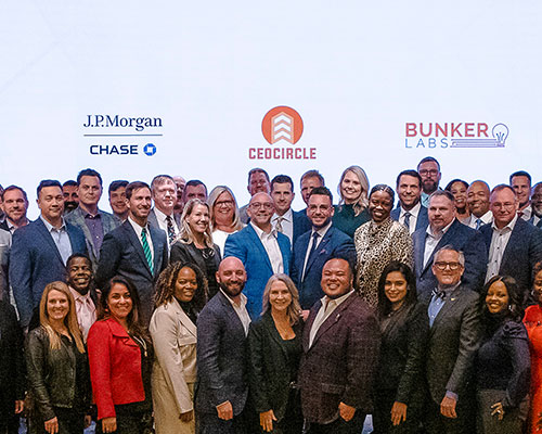 Large group of people pose in front of a background displaying J.P.Morgan Chase, CEO Circle, and Bunker Labs logos.