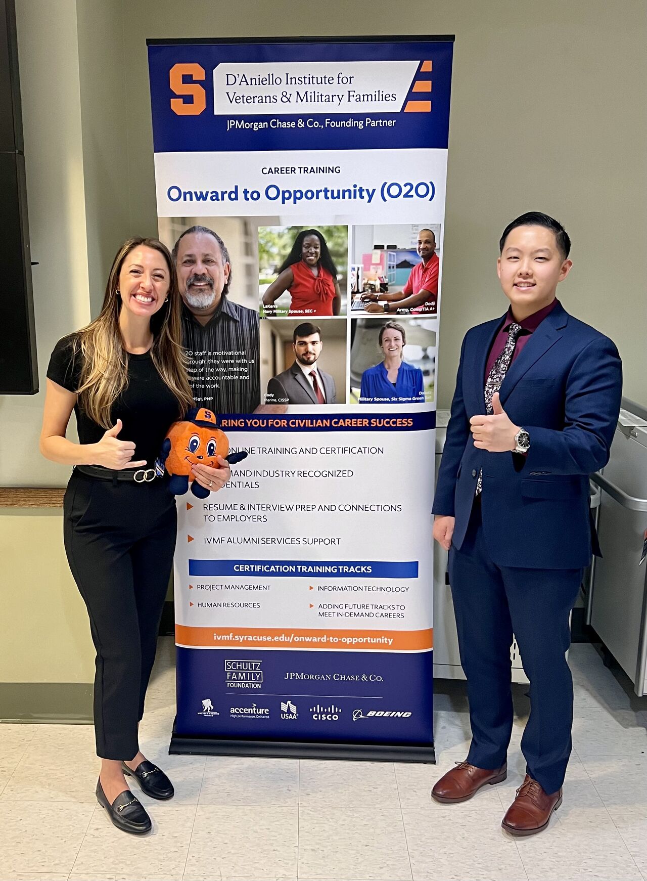 O2O program manage Colleen durm standing with participant infront of signage. 
