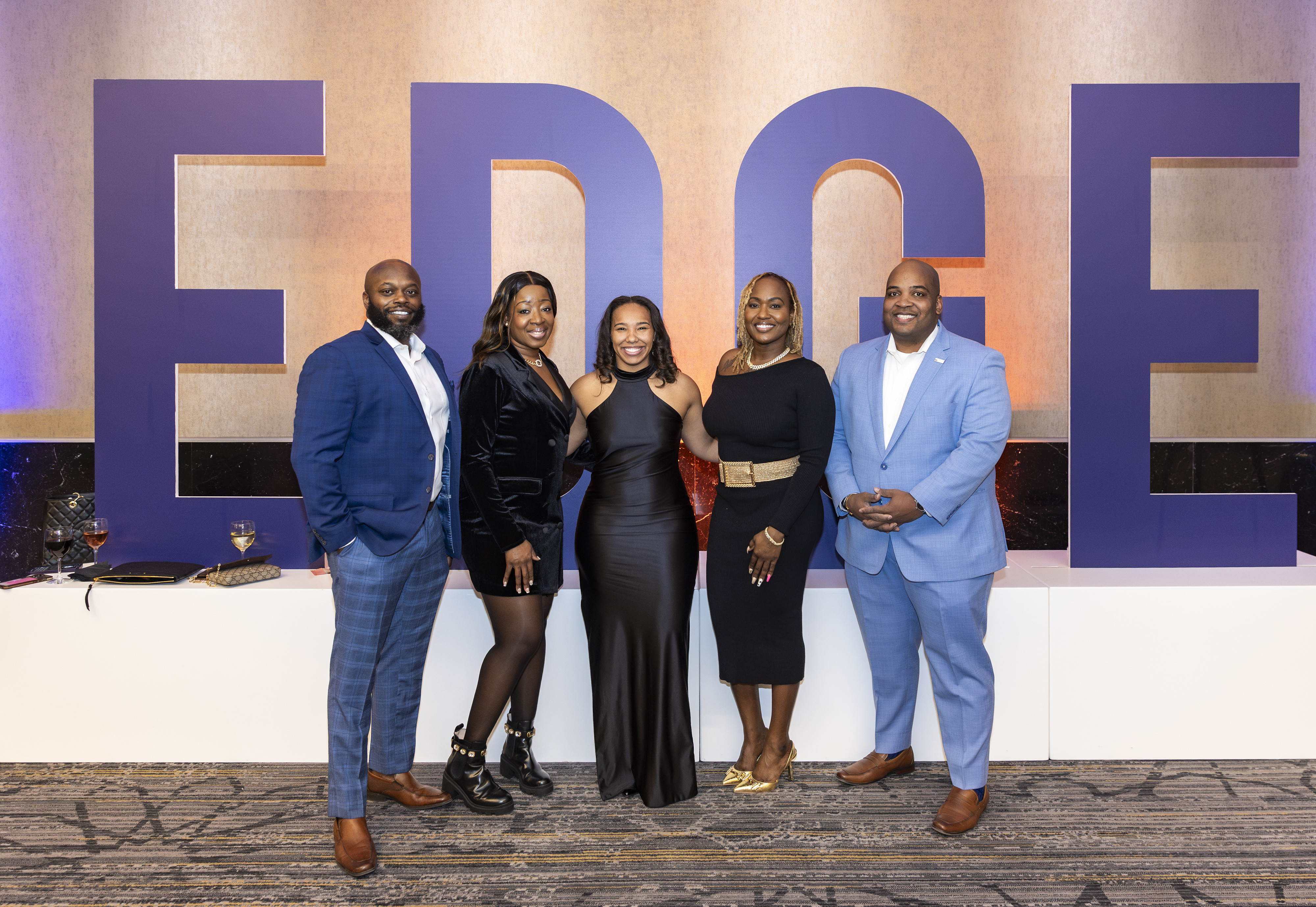 Edge participants standing in front of EDGE signage. 
