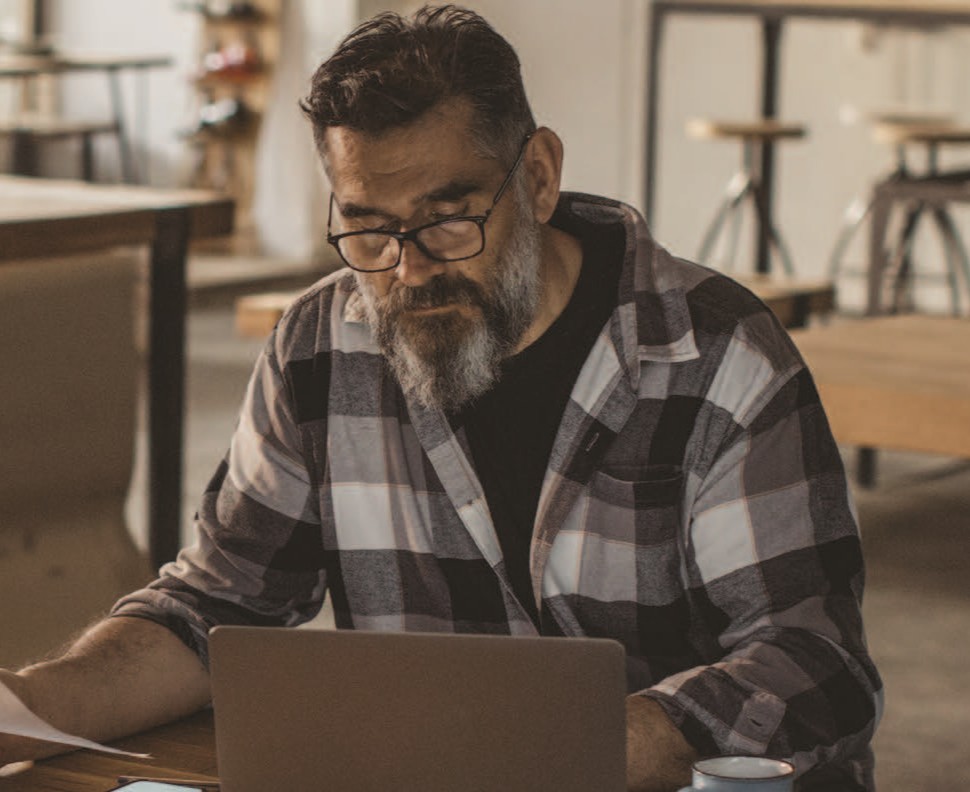 Veteran working on his computer to run his business. 