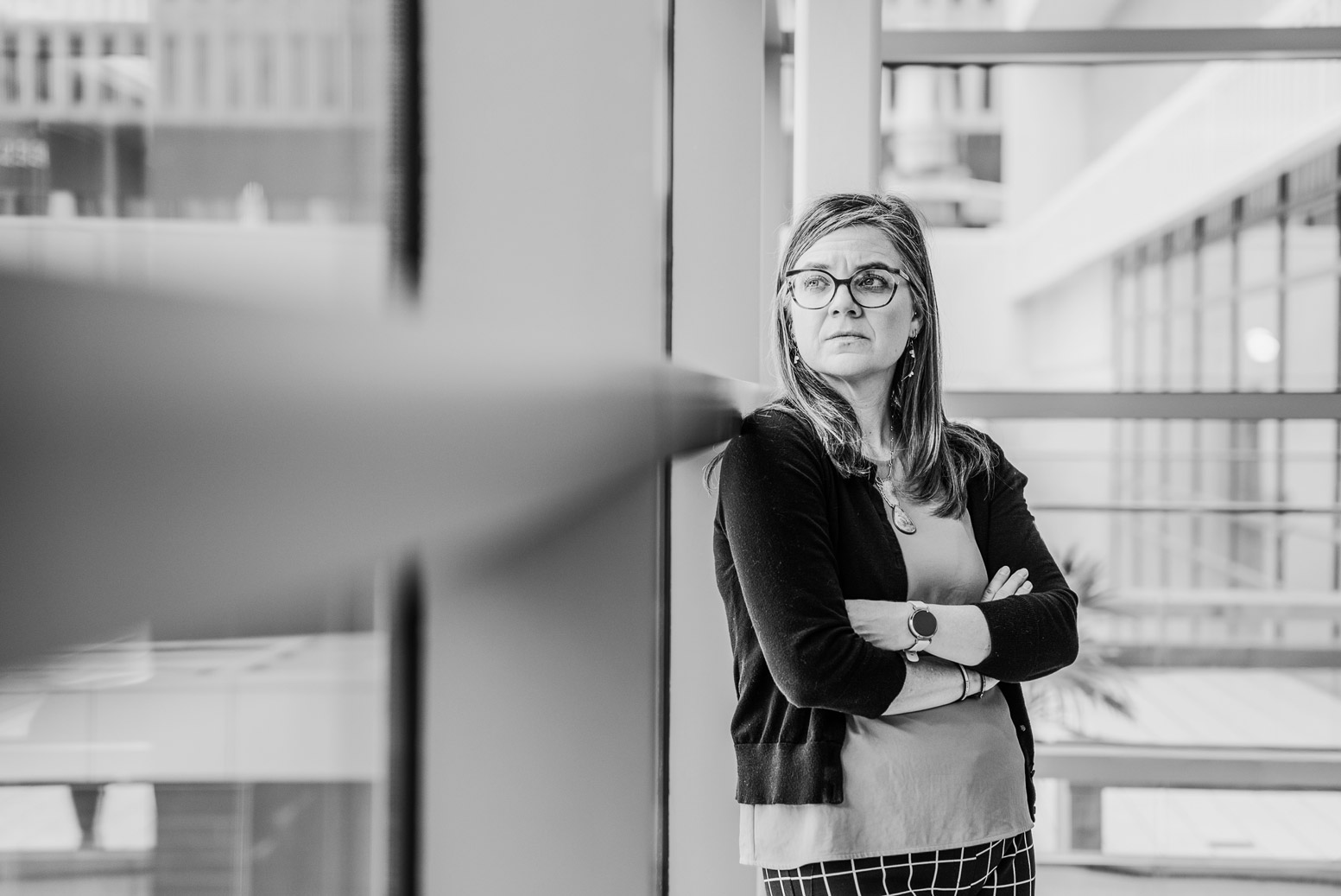 Military spouse leaning against glass looking out.