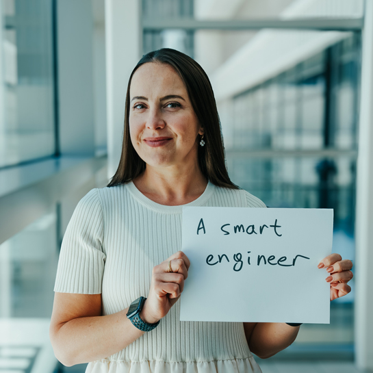 Military spouse holding a sign that says "a smart engineer"