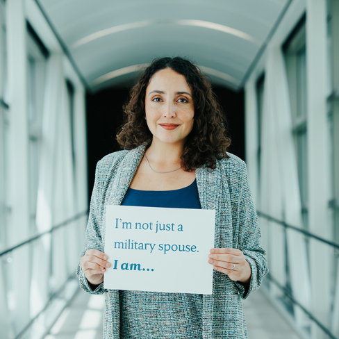 Military spouse holding up sign that says "I'm not just a military spouse. I am..."