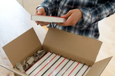 Unpacking books from a box.