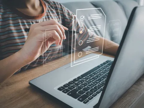 A graphic popping out of a open laptop representing a digital checklist.
