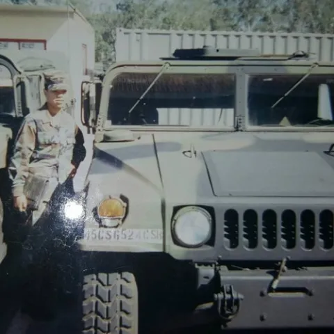 dr wakeena dickens in uniform near an armored vehicle. 