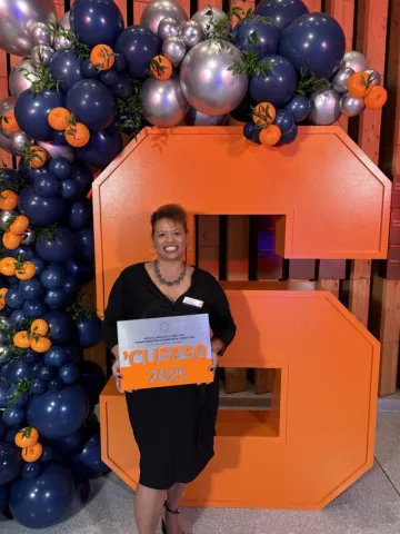 Nicole Wallace posing with her Cuse50 award.