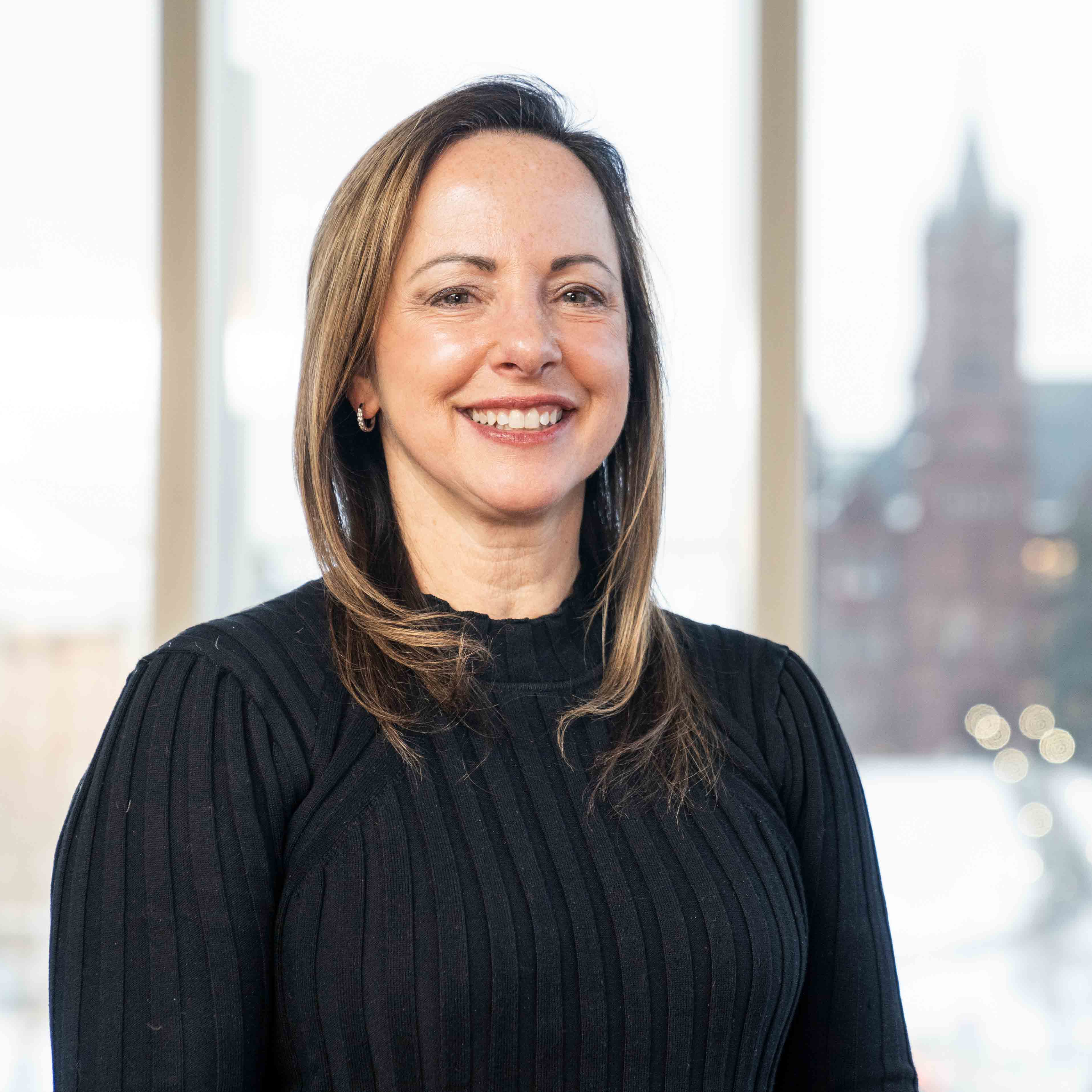 Headshot of Beth Kubala wearing a black shirt in front of a light background.