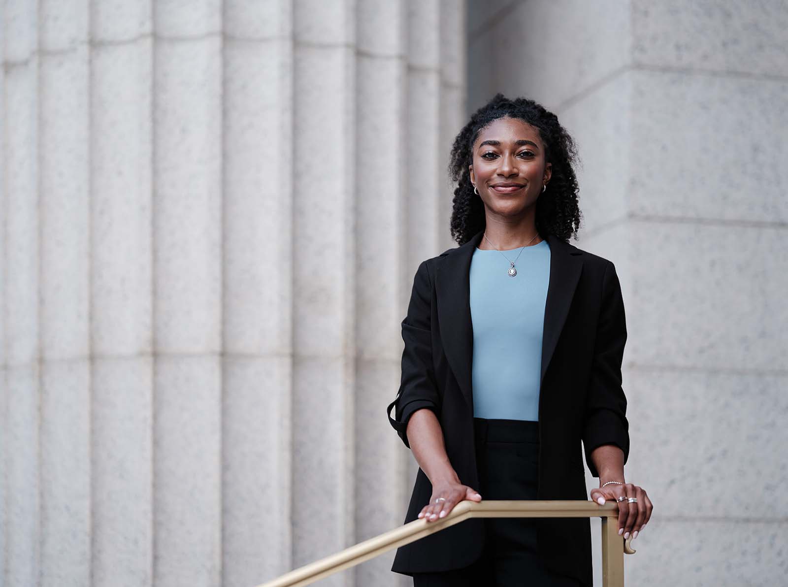 Lela Lanier stands in front of a white government column outside on a staircase.