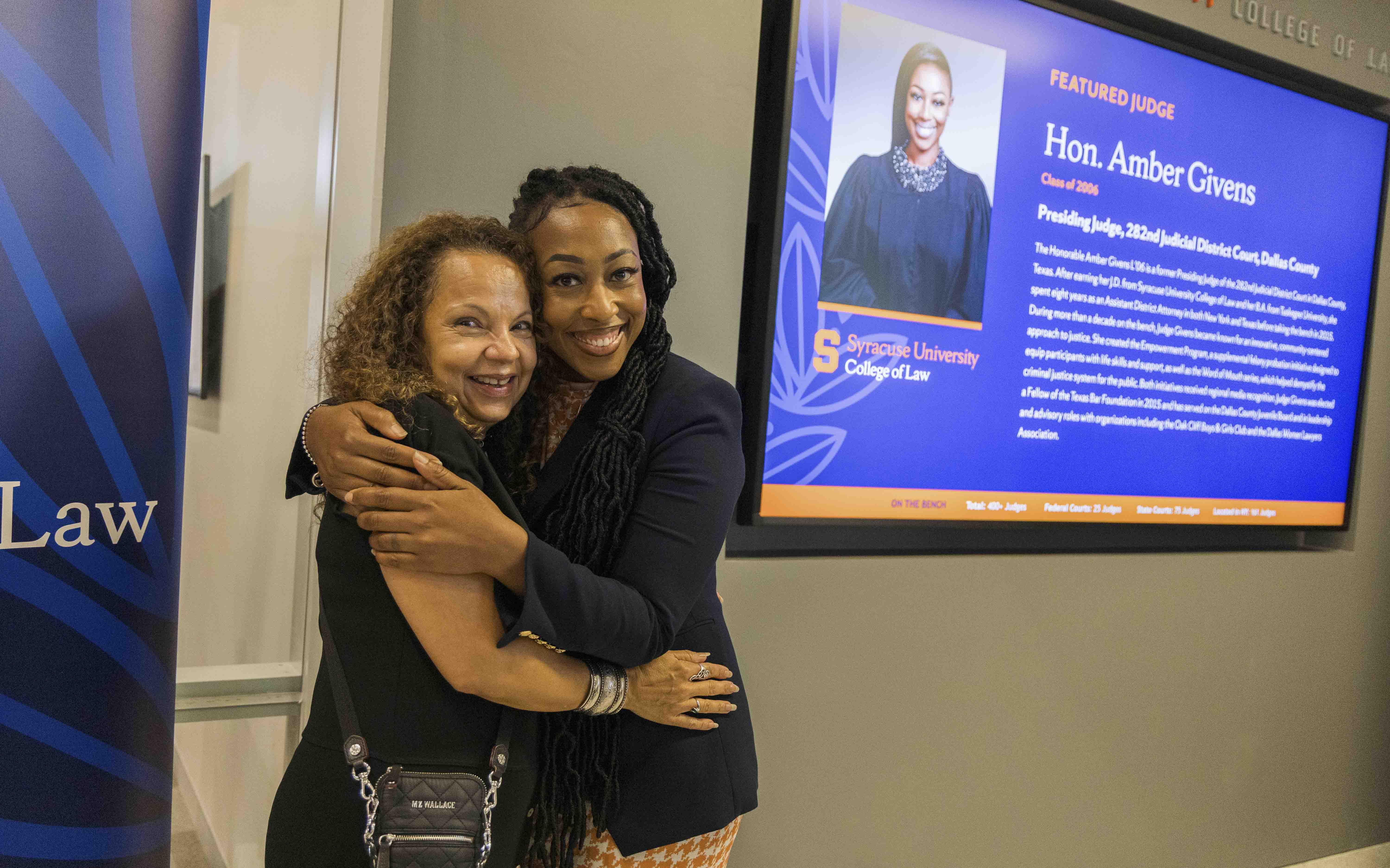 Suzette Melendez hugs Judge Givens in front of her screen at the unveiling.