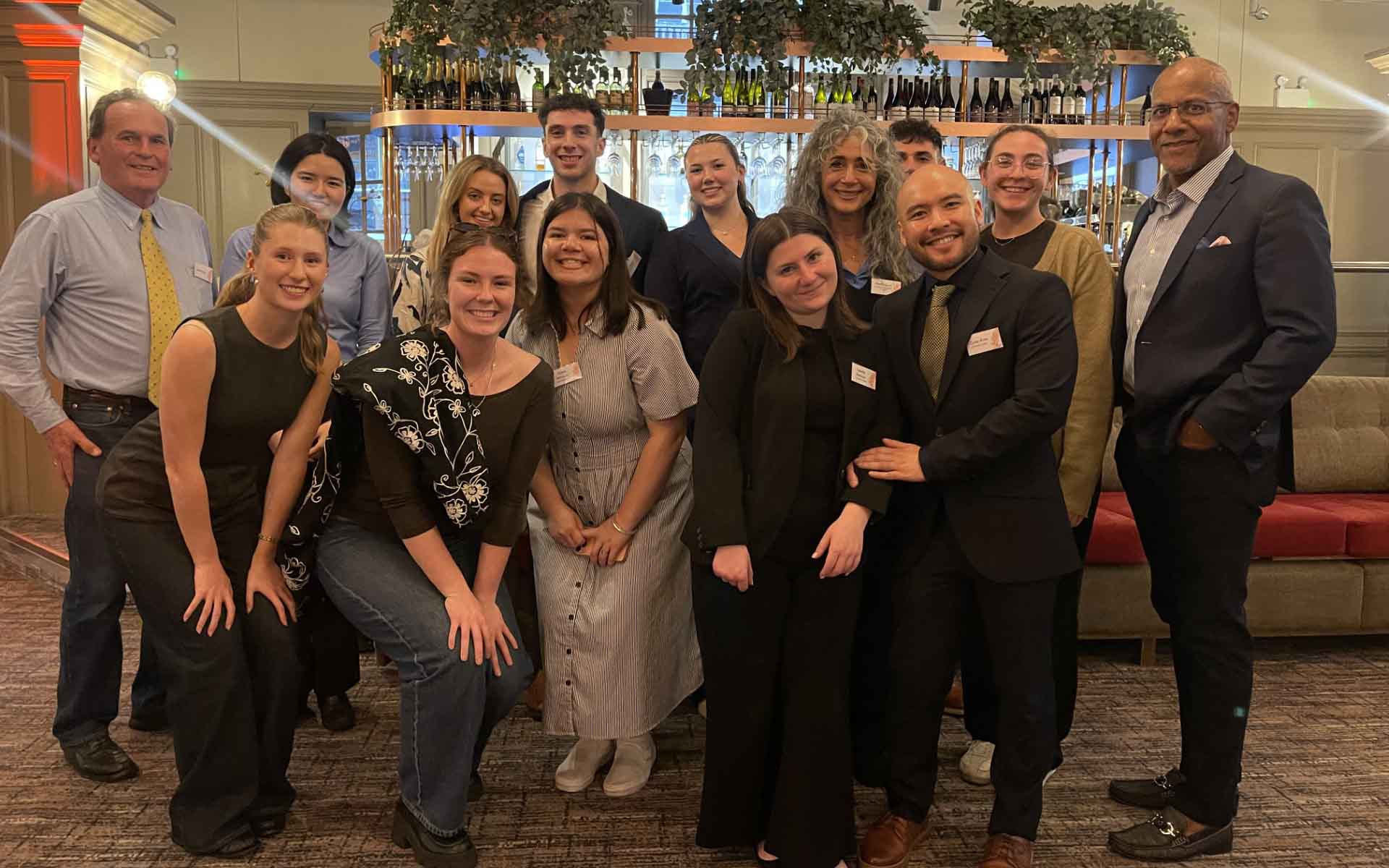 Group of students and professors smiles for a group shot in london at an event.