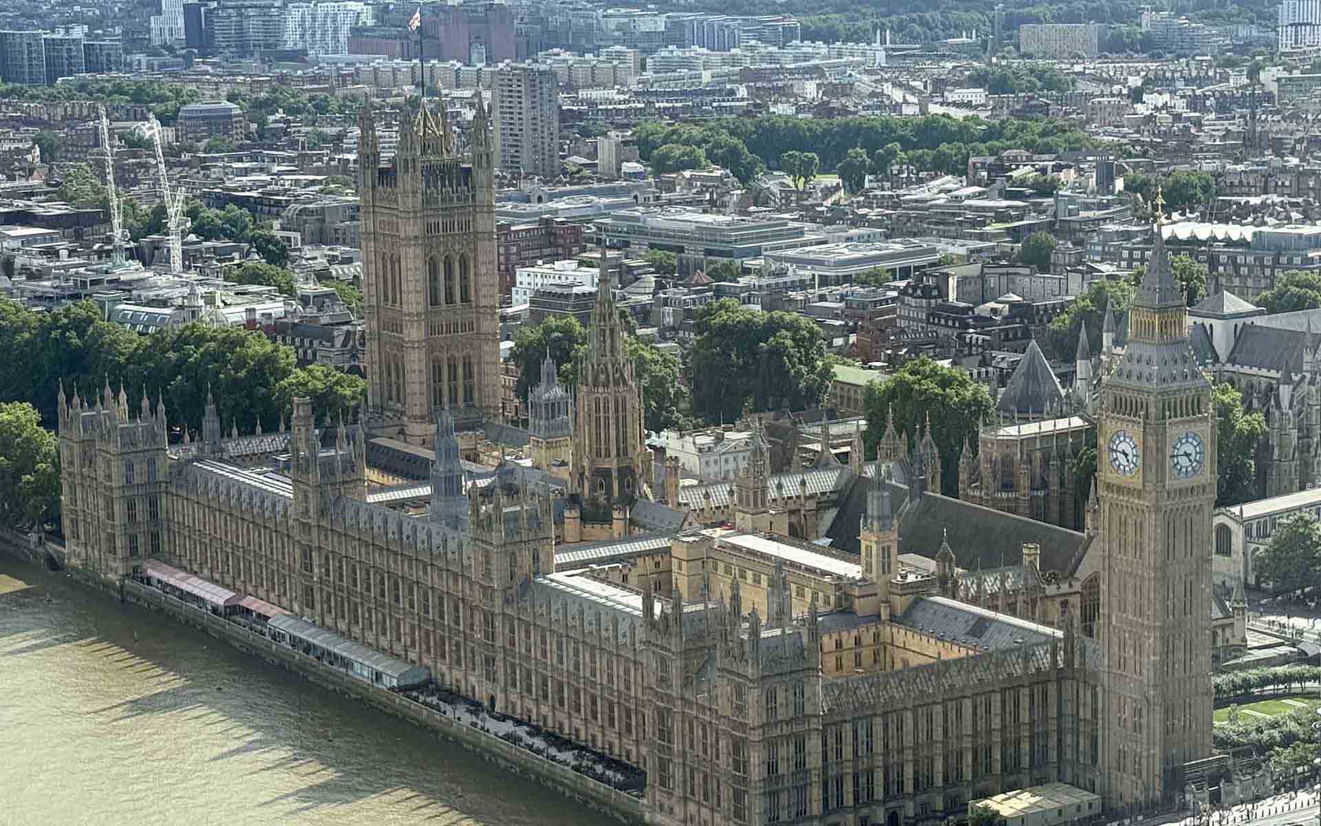 Aerial view of big ben in london and the river in front of it.