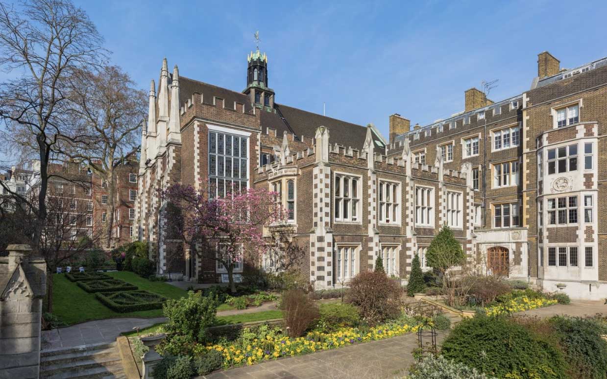 Photo of building in London with a brown stone exterior and white trim.