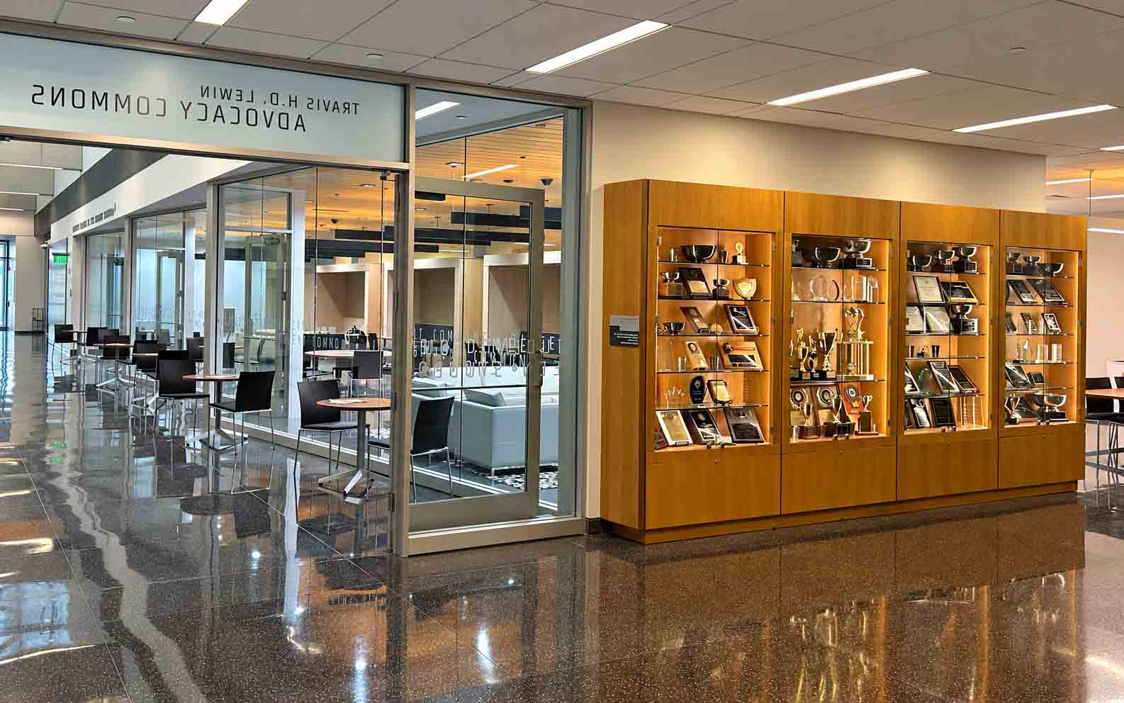 Side view of new student commons with Advocacy trophy wall, and looking down the hallway.