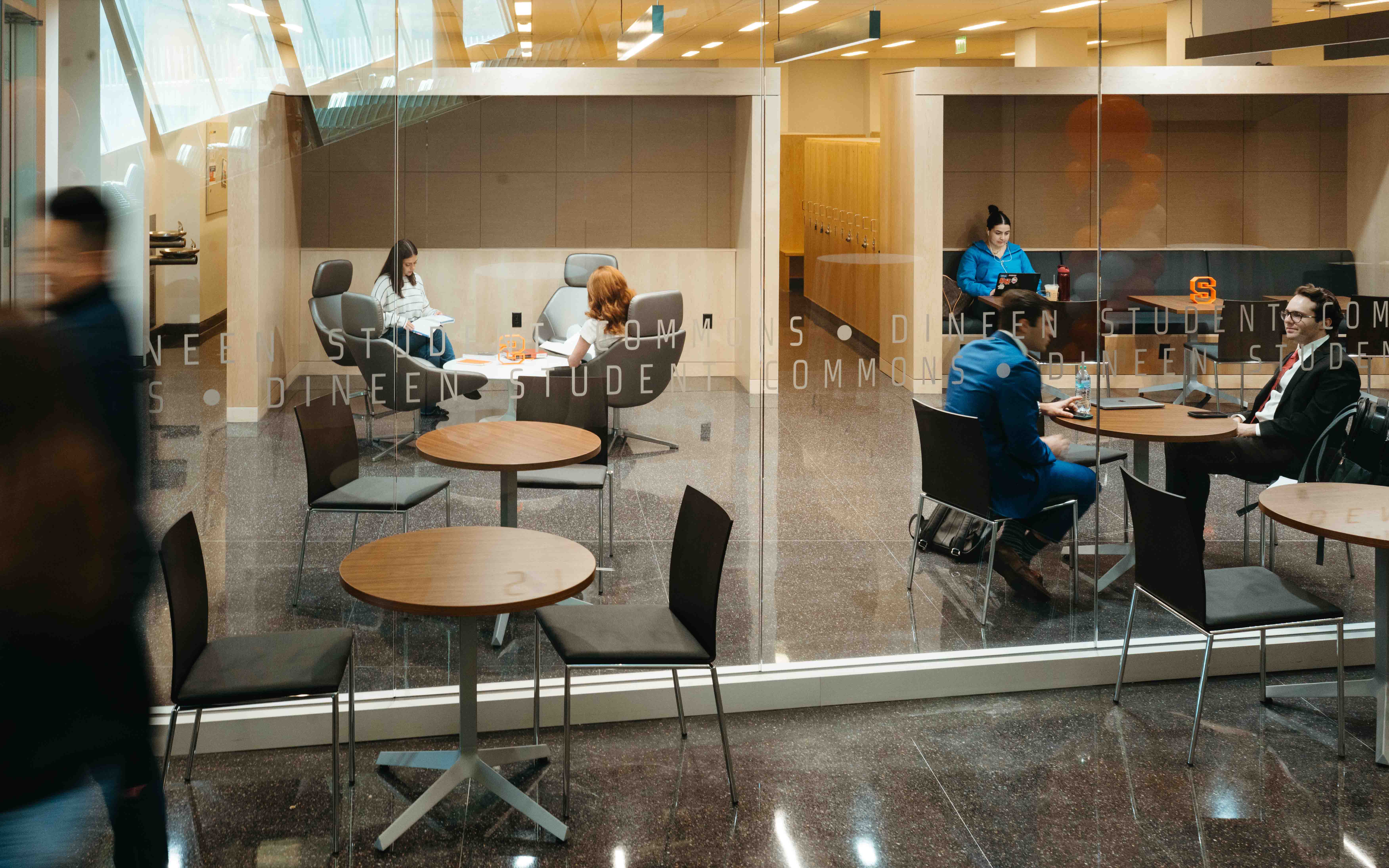 Students gather and study around round tables in the new student commons. 
