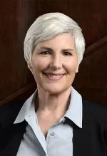 Headshot of woman in dark suit with light shirt smiling