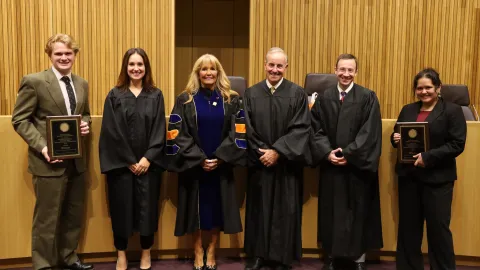 Six people standing wearing judicial robes or business attire.
